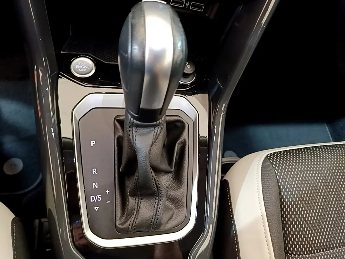 Le levier de vitesse automatique noir et argenté du Volkswagen T-Roc 1.5 TSI, avec bouton démarrage visible, vue intérieure rapprochée.