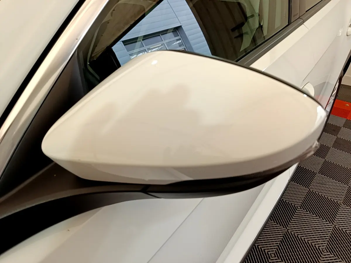 Gros plan sur le rétroviseur droit blanc d'un Volkswagen T-Roc 1.5 TSI 150 EVO Carat DSG7 2020, vue latérale.