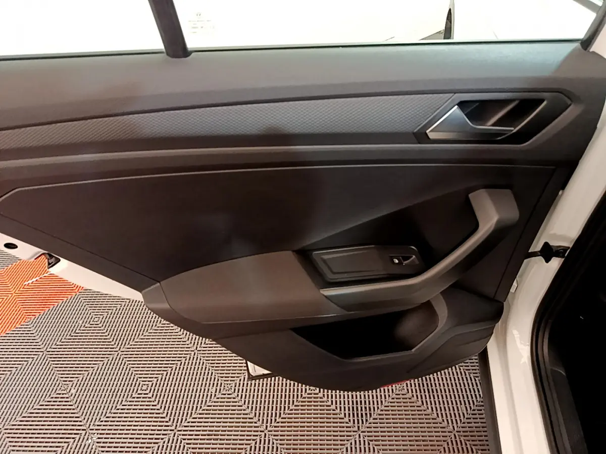 Vue rapprochée de la porte avant gauche blanche d'un Volkswagen T-Roc 2020 avec garniture intérieure noire.