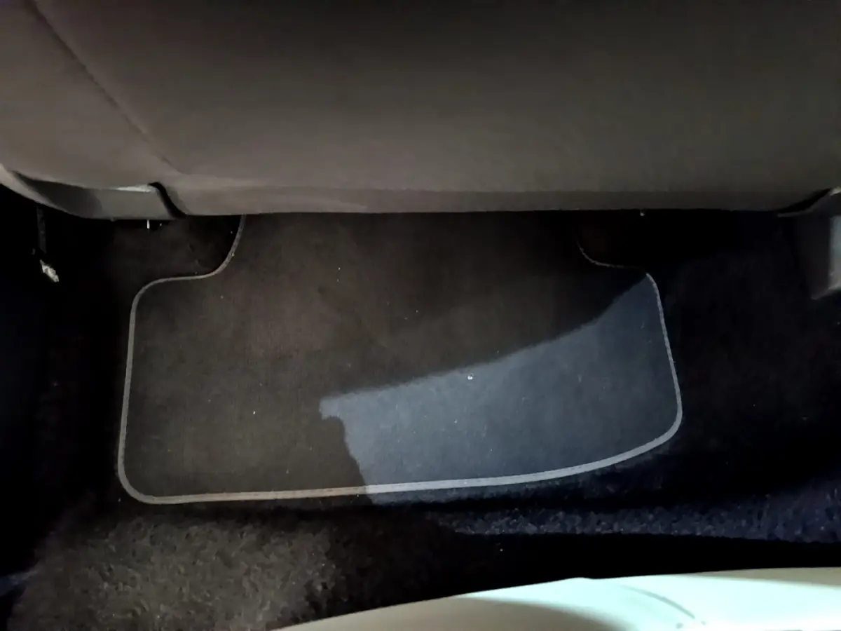 Tapis de sol noir sous le siège arrière d'un Volkswagen T-Roc blanc 2020, vue intérieure au sol.
