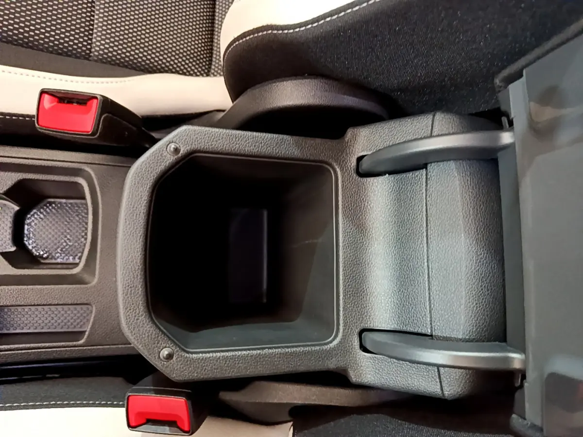 Gros plan sur la console centrale noire avec accoudoir et ceintures rouges du Volkswagen T-Roc blanc 2020.