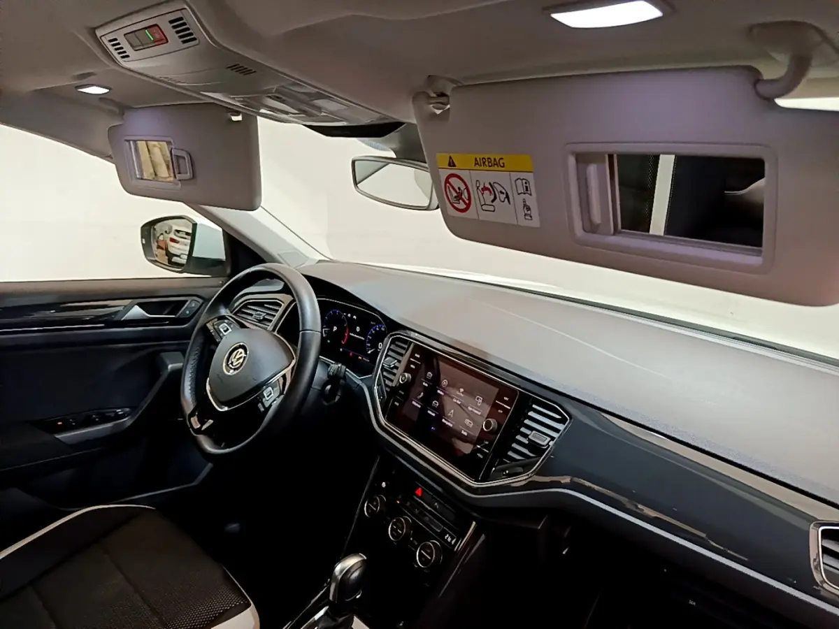 Intérieur noir du Volkswagen T-Roc 1.5 TSI 2020 vu côté conducteur, avec tableau de bord digital et écran tactile central.