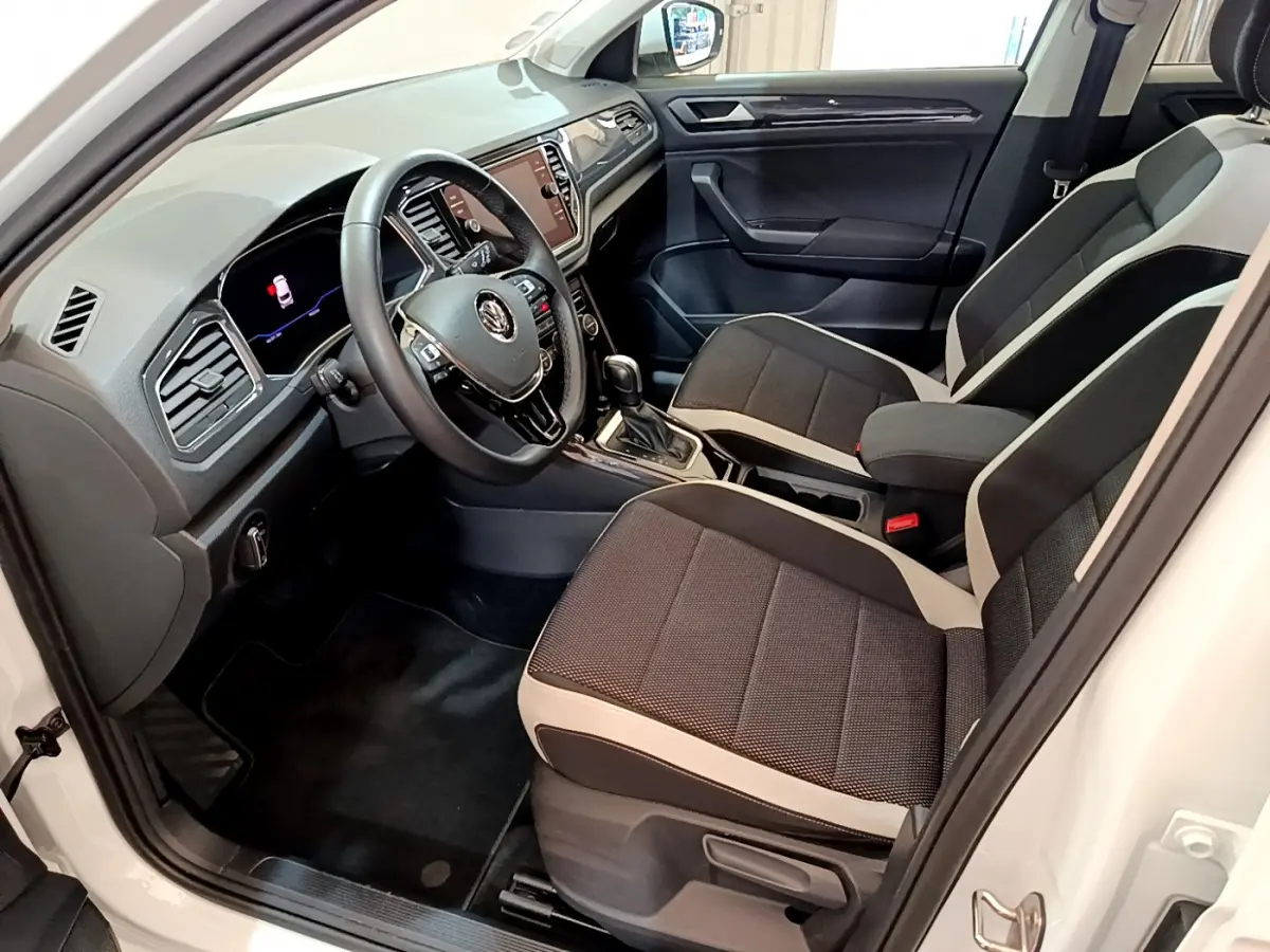 Intérieur avant droit du Volkswagen T-Roc blanc 2020 avec sièges bicolores et tableau de bord moderne tactile.