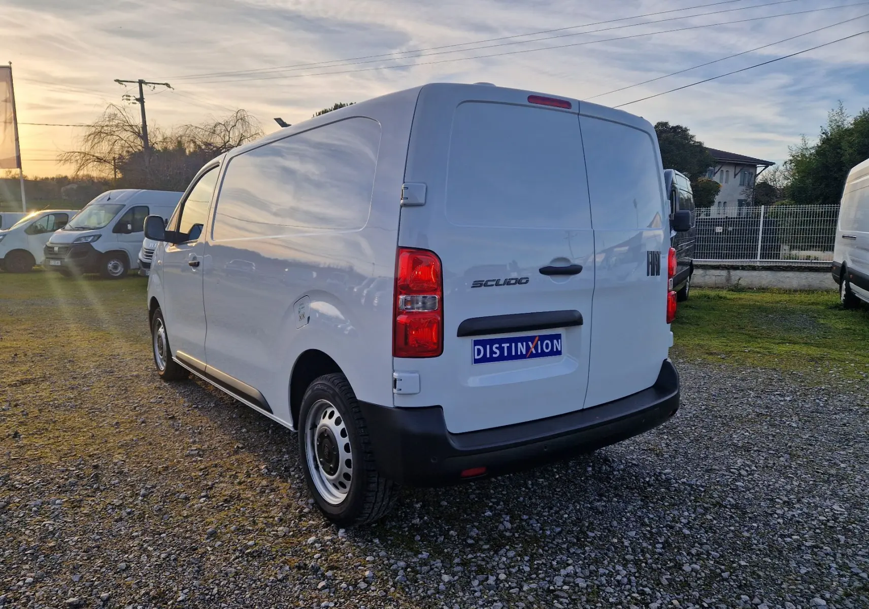 Vue 3/4 arrière droite d’un FIAT Scudo Fourgon blanc 2024 avec hayon fermé sur un parking extérieur.