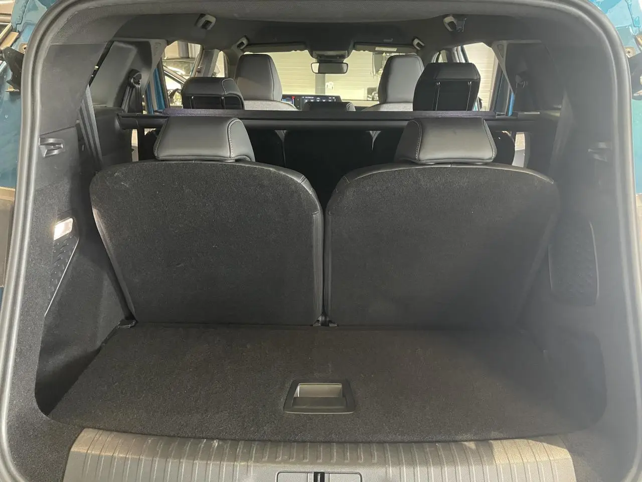 Vue arrière du coffre du Peugeot 5008 Bleu Obsession avec banquette 3e rangée relevée et intérieur noir.