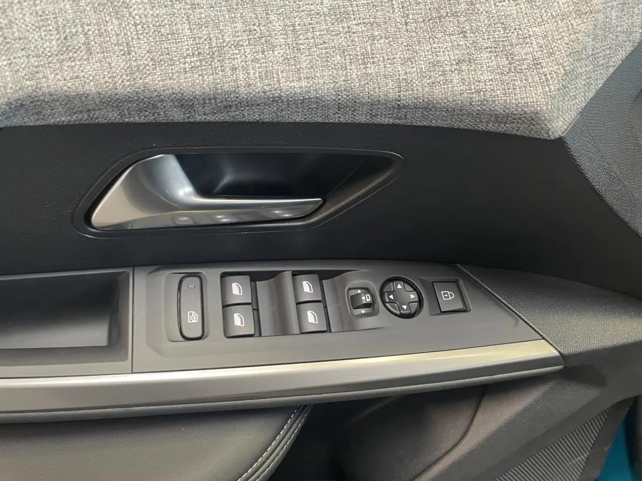 Commande des vitres et rétroviseurs côté conducteur du Peugeot 5008 2025, intérieur noir avec surpiqûres grises.