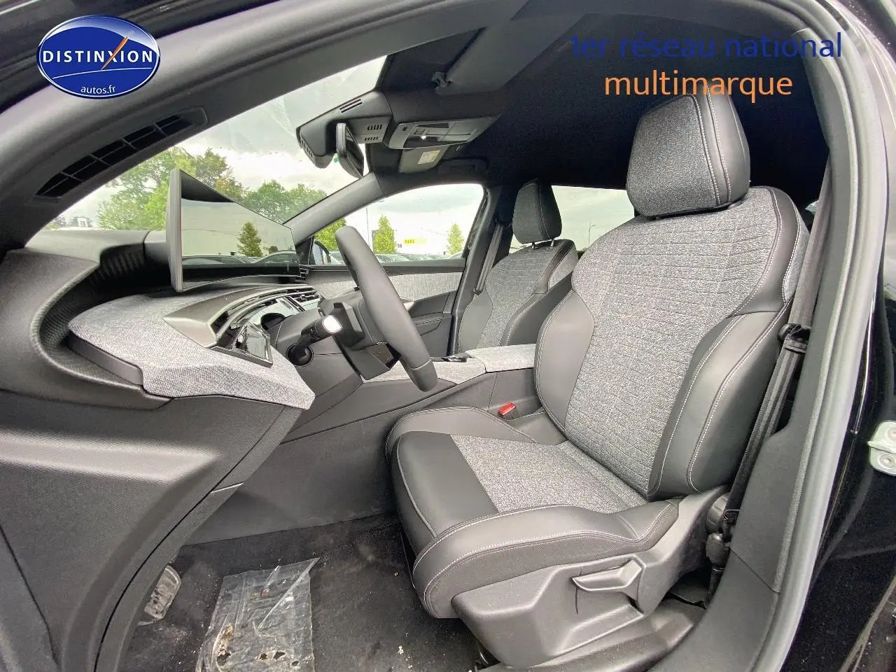 Vue intérieure côté conducteur du Peugeot 5008 Hybrid 145 allure e-dcs6 2025 noir, sièges tissu gris et cuir noir.