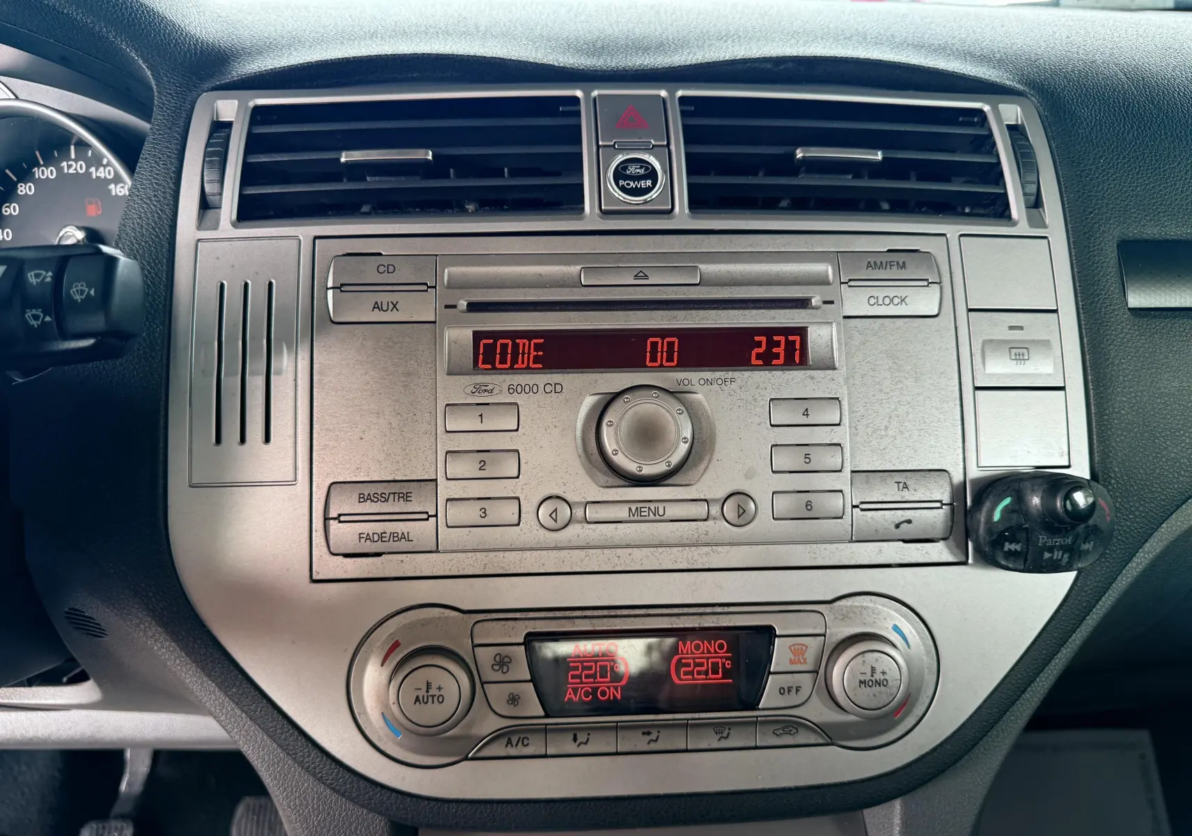 Tableau de bord gris du Ford Kuga 2012 avec système audio 6000 CD et affichage digital rouge en gros plan.