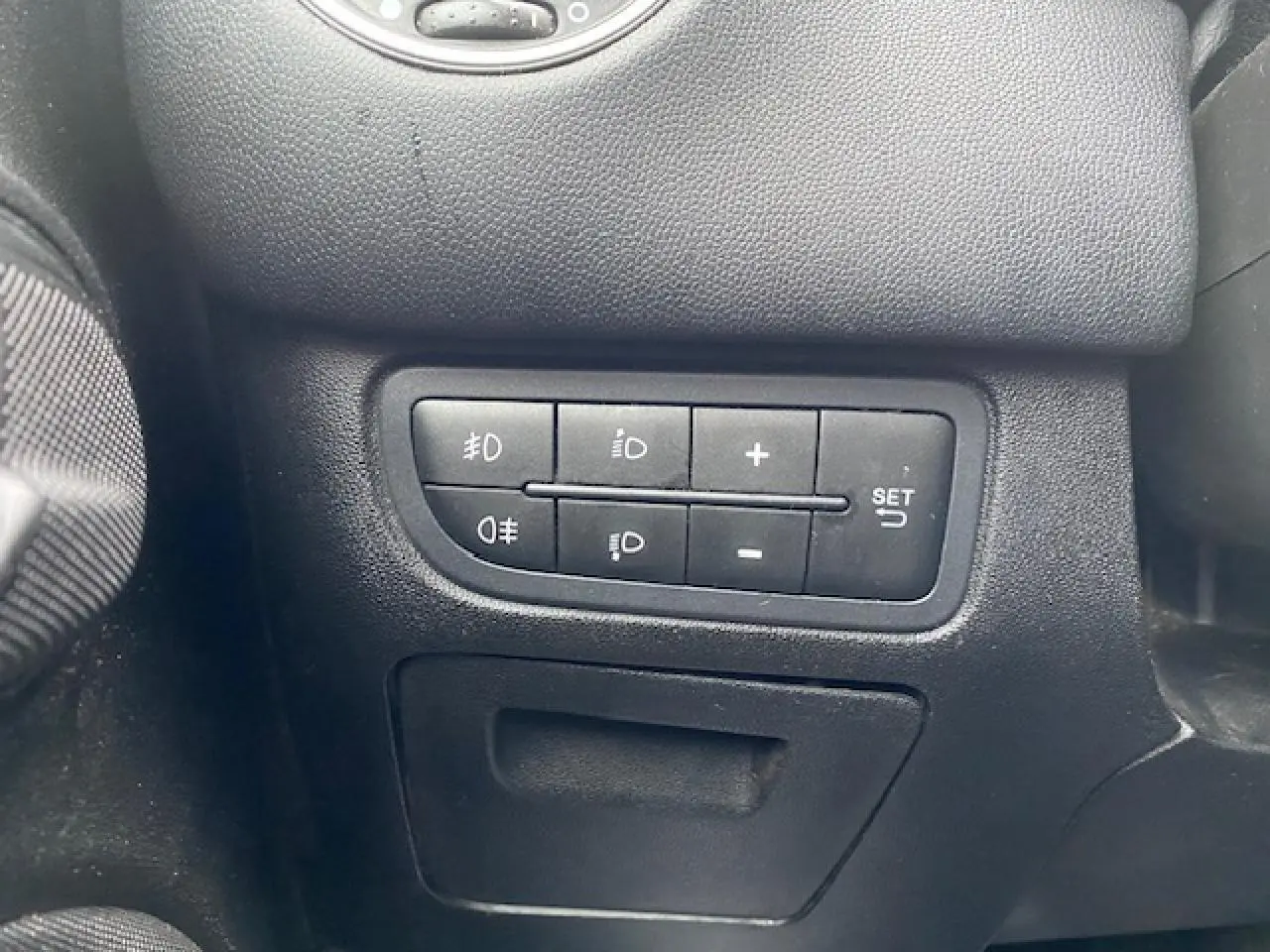 Gros plan sur les commandes d'éclairage et réglages du tableau de bord d'une Fiat Grande Punto gris métallisé.