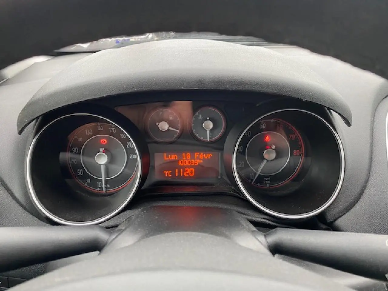 Vue rapprochée du tableau de bord de la Fiat Grande Punto gris, affichant le compteur et l'ordinateur de bord.