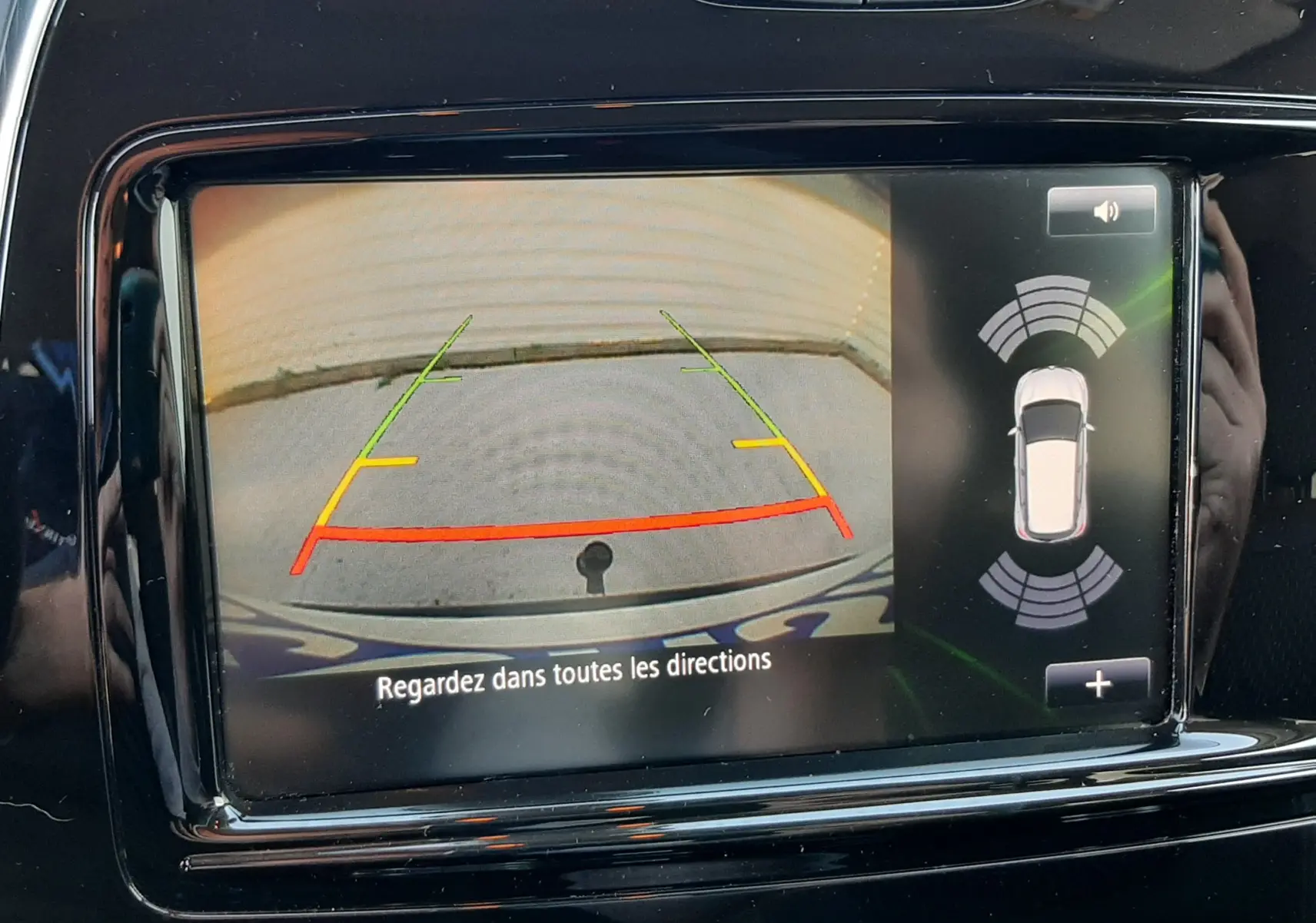 Écran multimédia montrant la caméra de recul du Renault Captur blanc nacré avec toit noir, vue intérieure du tableau de bord.