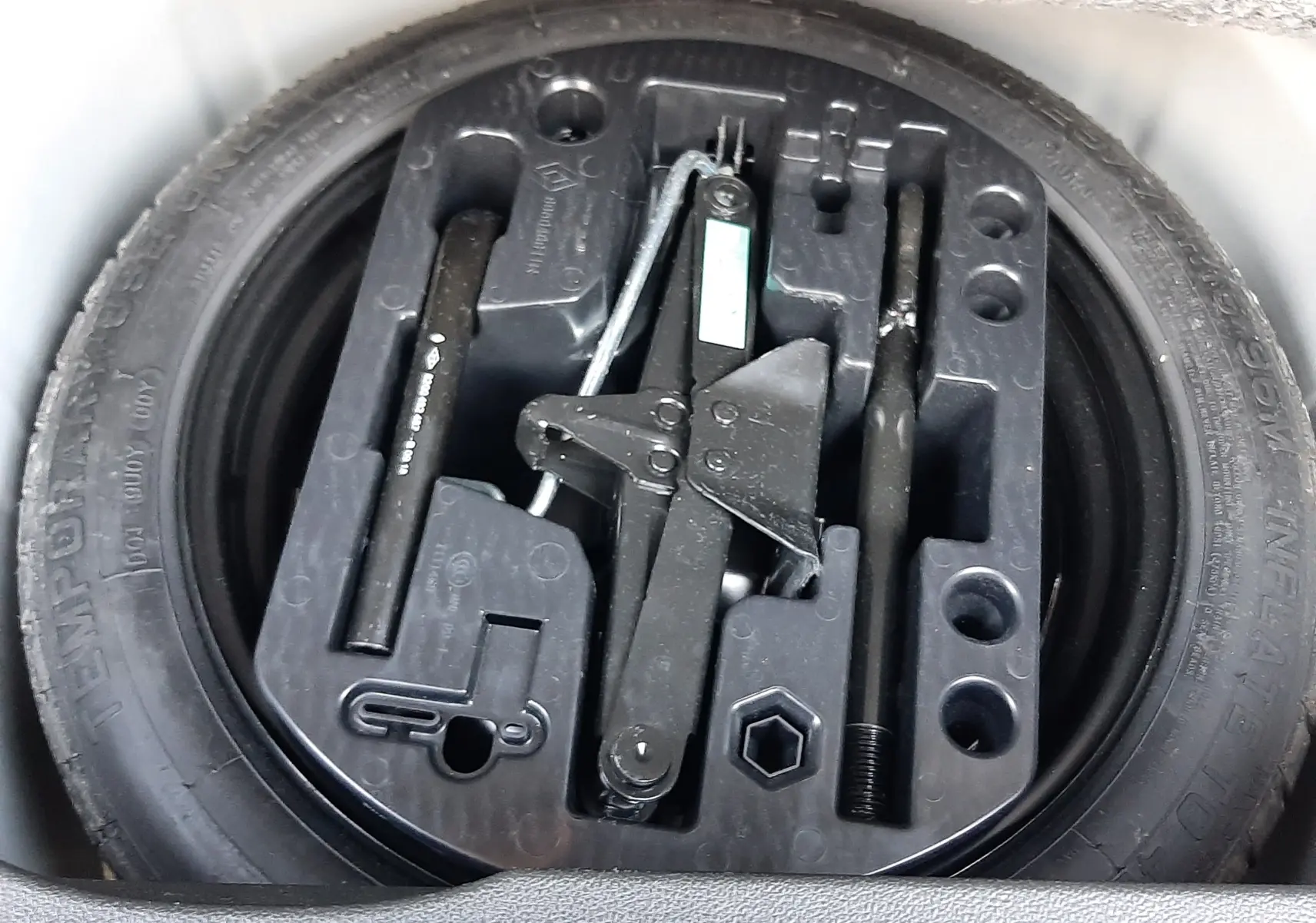 Gros plan sur la roue de secours et le kit d'outils de bord du Renault Captur blanc nacré toit noir 2019.