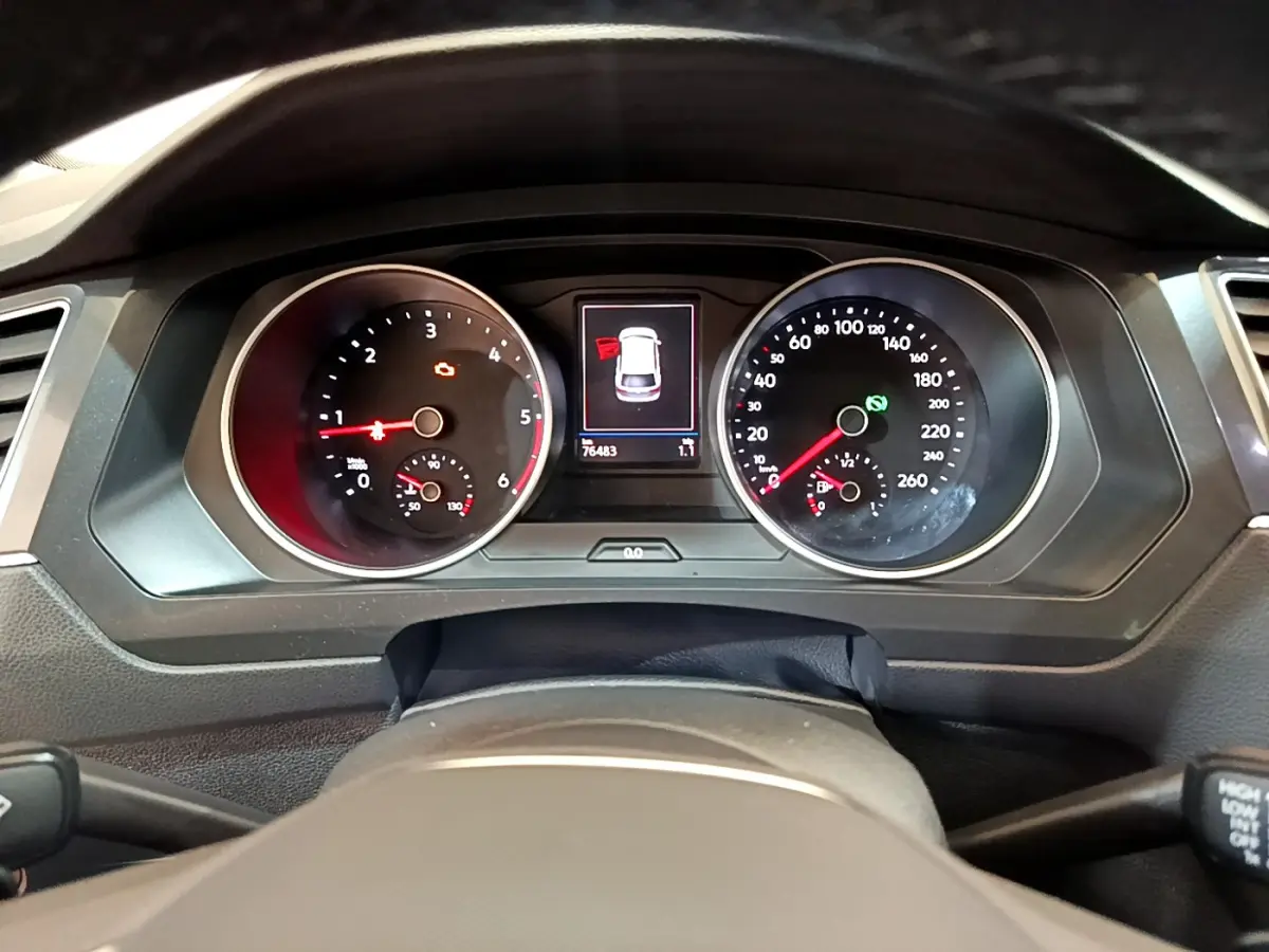 Vue intérieure du tableau de bord du Volkswagen Tiguan noir 2021, avec écran tactile et volant cuir multifonctions.