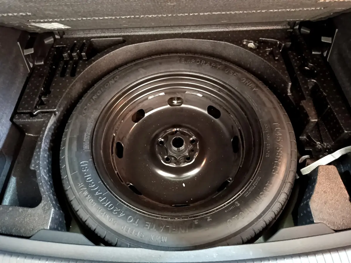 Roue de secours noire vue de dessus dans le coffre du Volkswagen Tiguan 2.0 TDI 150 DSG7 Life Business 2021.