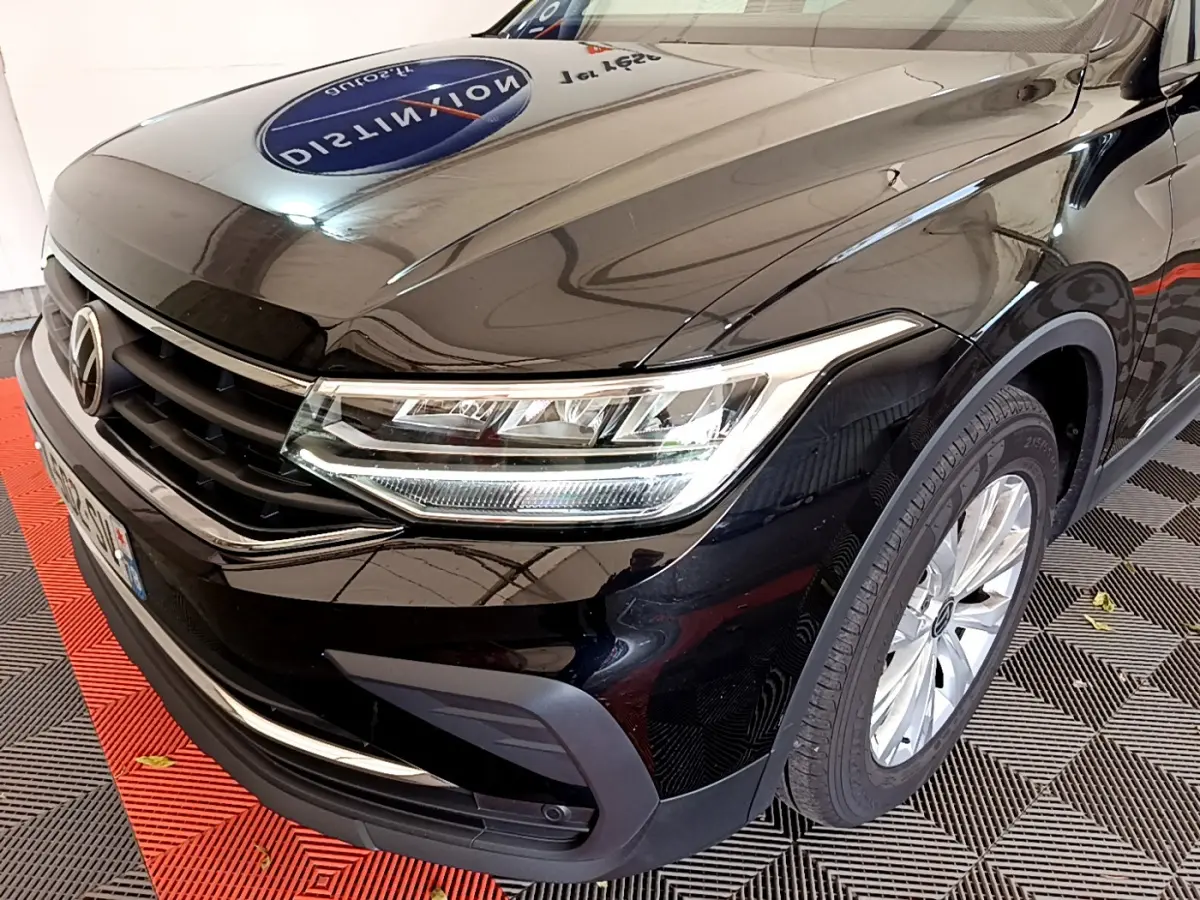 Vue 3/4 avant droit d'un Volkswagen Tiguan noir 2021 avec phares LED et jantes alliage argentées.