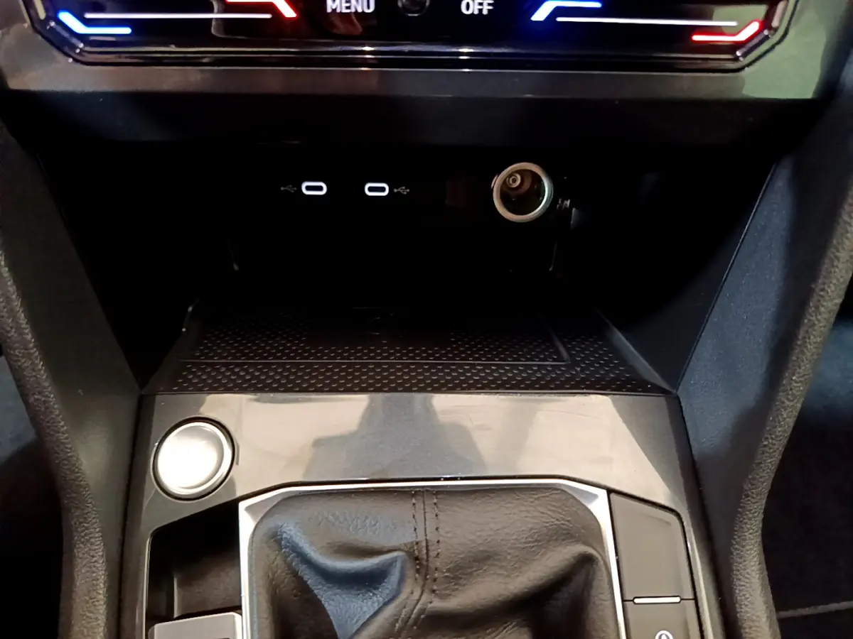 Gros plan sur la console centrale du Volkswagen Tiguan 2021 noire, avec levier de vitesse cuir et ports USB visibles.