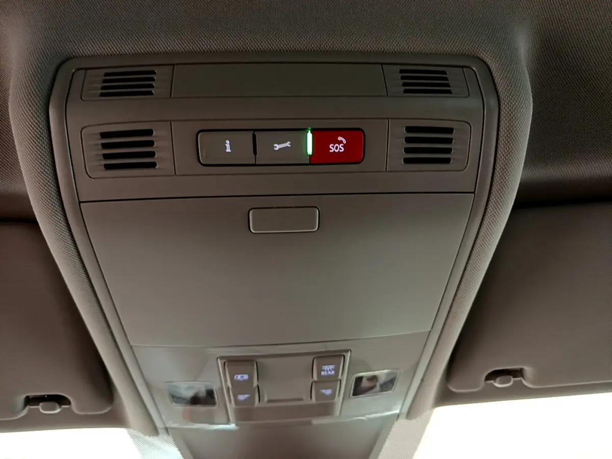 Panneau de commandes au plafond intérieur du Volkswagen Tiguan 2.0 TDI noir, avec bouton SOS rouge éclairé.