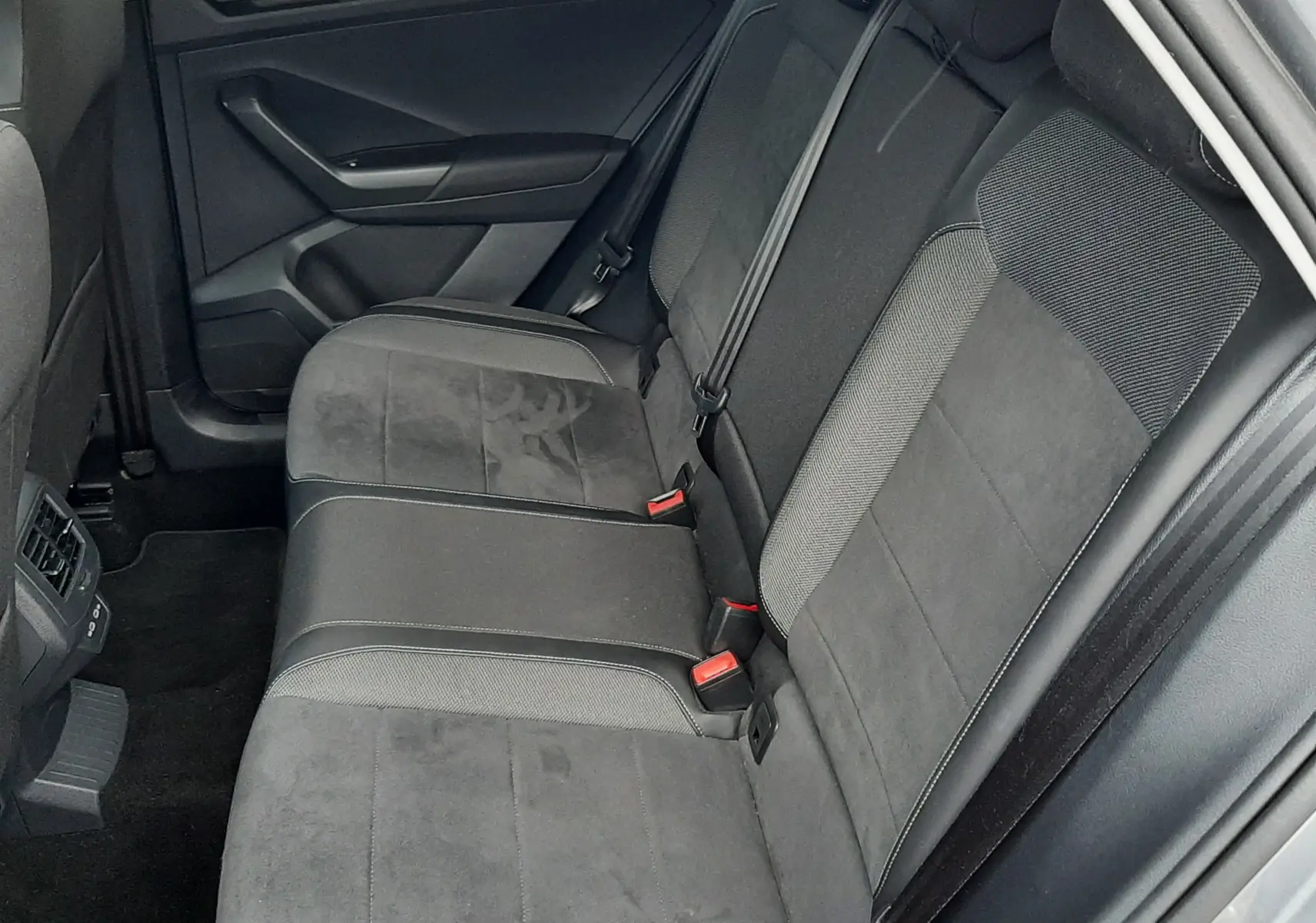Vue intérieure côté conducteur du Volkswagen T-Roc 2.0 TDI 150 CH STYLE DSG7 avec sièges tissu noir et accoudoir central.