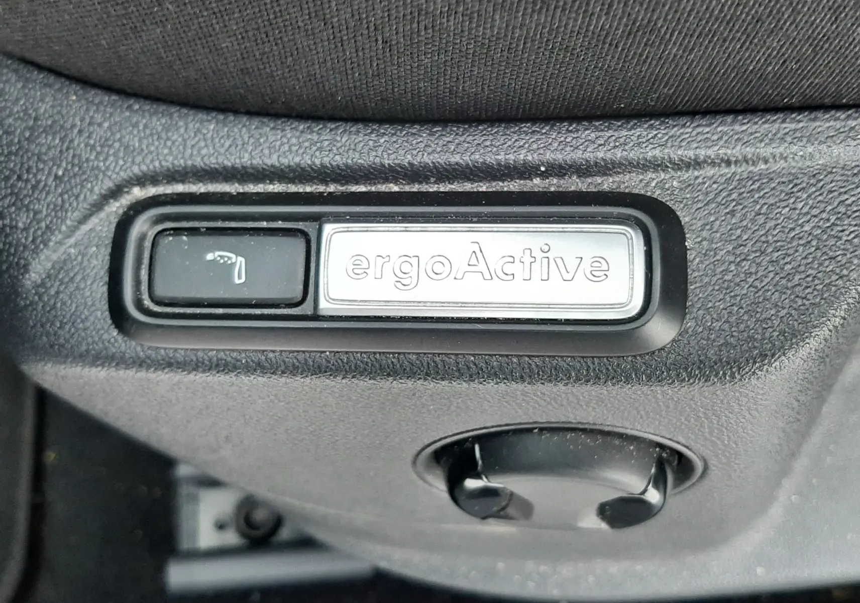 Gros plan sur les commandes de lève-vitres et rétroviseurs côté conducteur du Volkswagen T-Roc gris pyrite 2023.