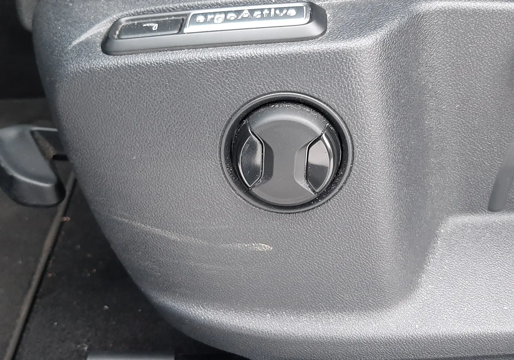 Gros plan sur la commande ergoActive du siège intérieur du Volkswagen T-Roc gris pyrite 2023.