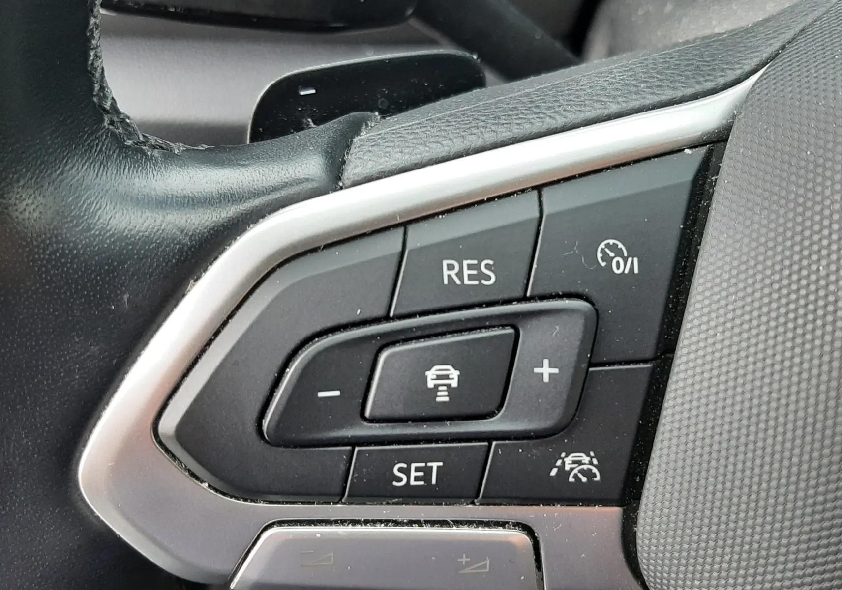 Commande des phares en gros plan sur tableau de bord noir du Volkswagen T-Roc gris pyrite 2023.