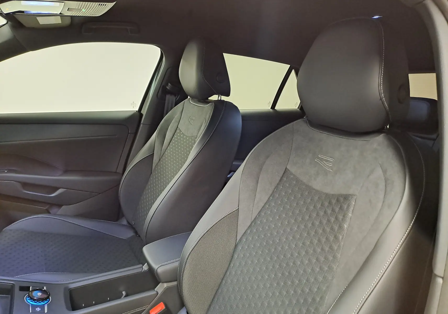 Vue intérieure côté avant droit du Volkswagen T-Roc 2026 R-Line, sièges en cuir et alcantara noirs avec surpiqûres blanches.