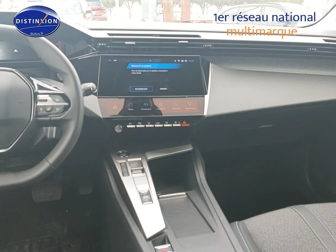 Vue intérieure de la Peugeot 308 SW 2025, tableau de bord et console centrale avec écran tactile et volant multifonction.