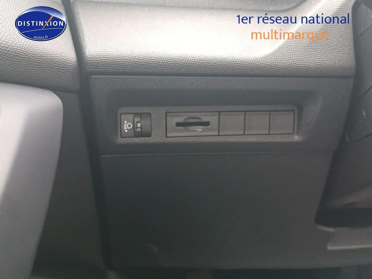Détail intérieur montrant les commandes d'éclairage sur le tableau de bord d'une Peugeot 308 SW gris sélénite.