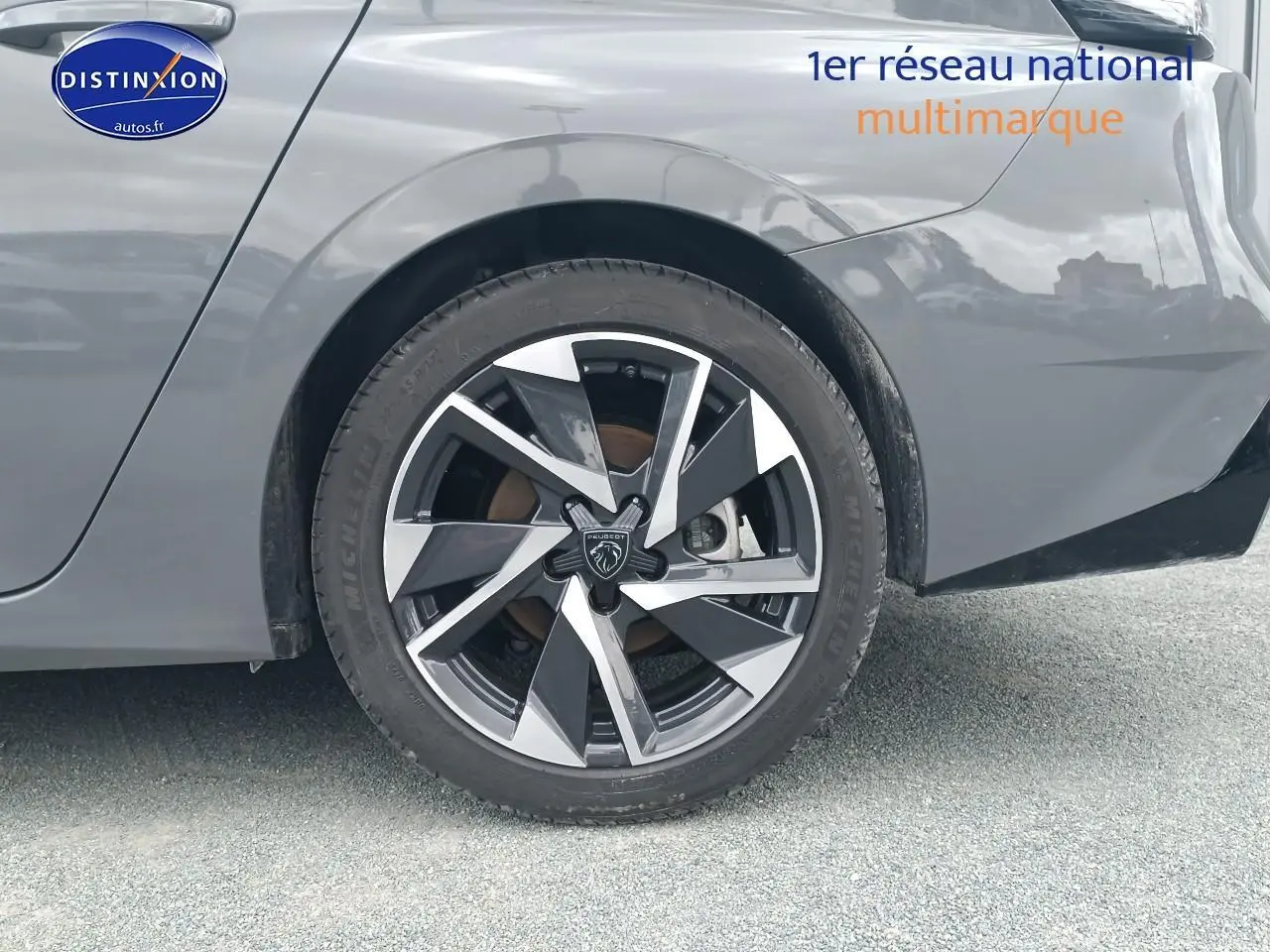 Gros plan sur la roue arrière droite d'une Peugeot 308 SW gris sélénite avec jante alu au design moderne.