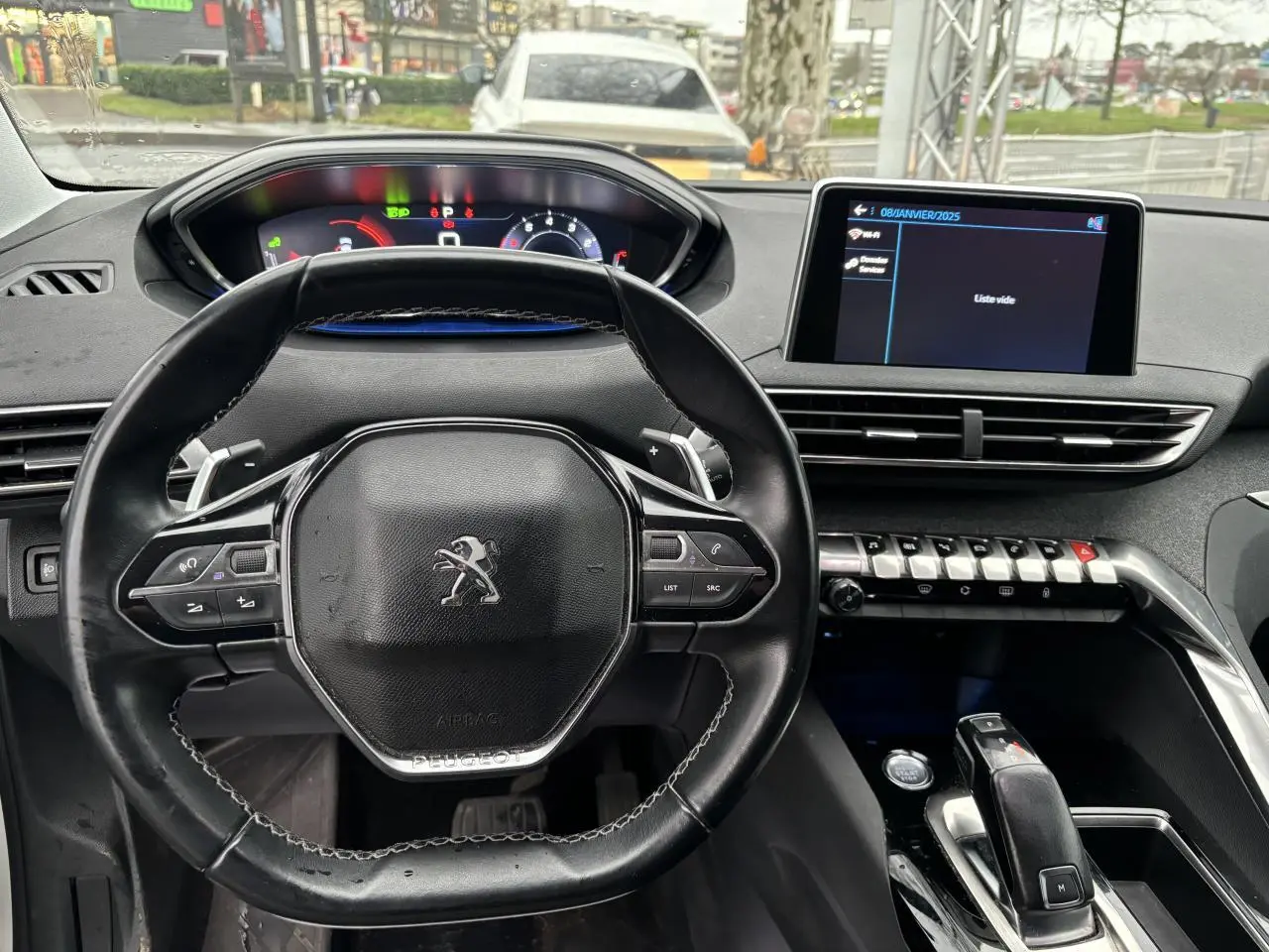 Vue intérieure centrée sur le volant compact et le tableau de bord numérique du Peugeot 3008 blanc de 2018.