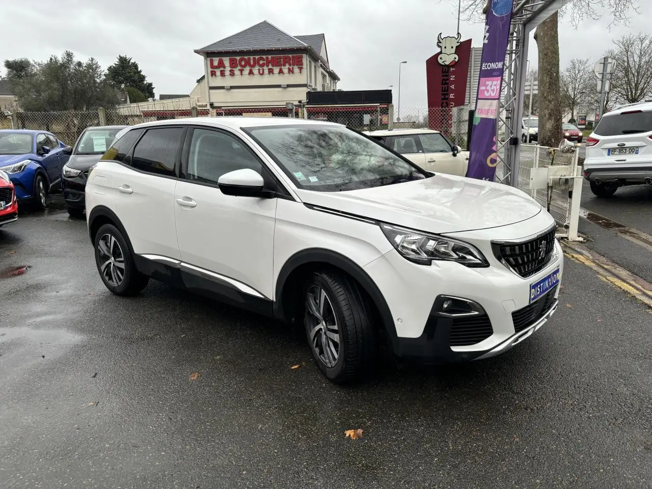Peugeot 3008 blanc nacré en 3/4 avant droit sur parking, avec jantes alliage et calandre noire distinctive.