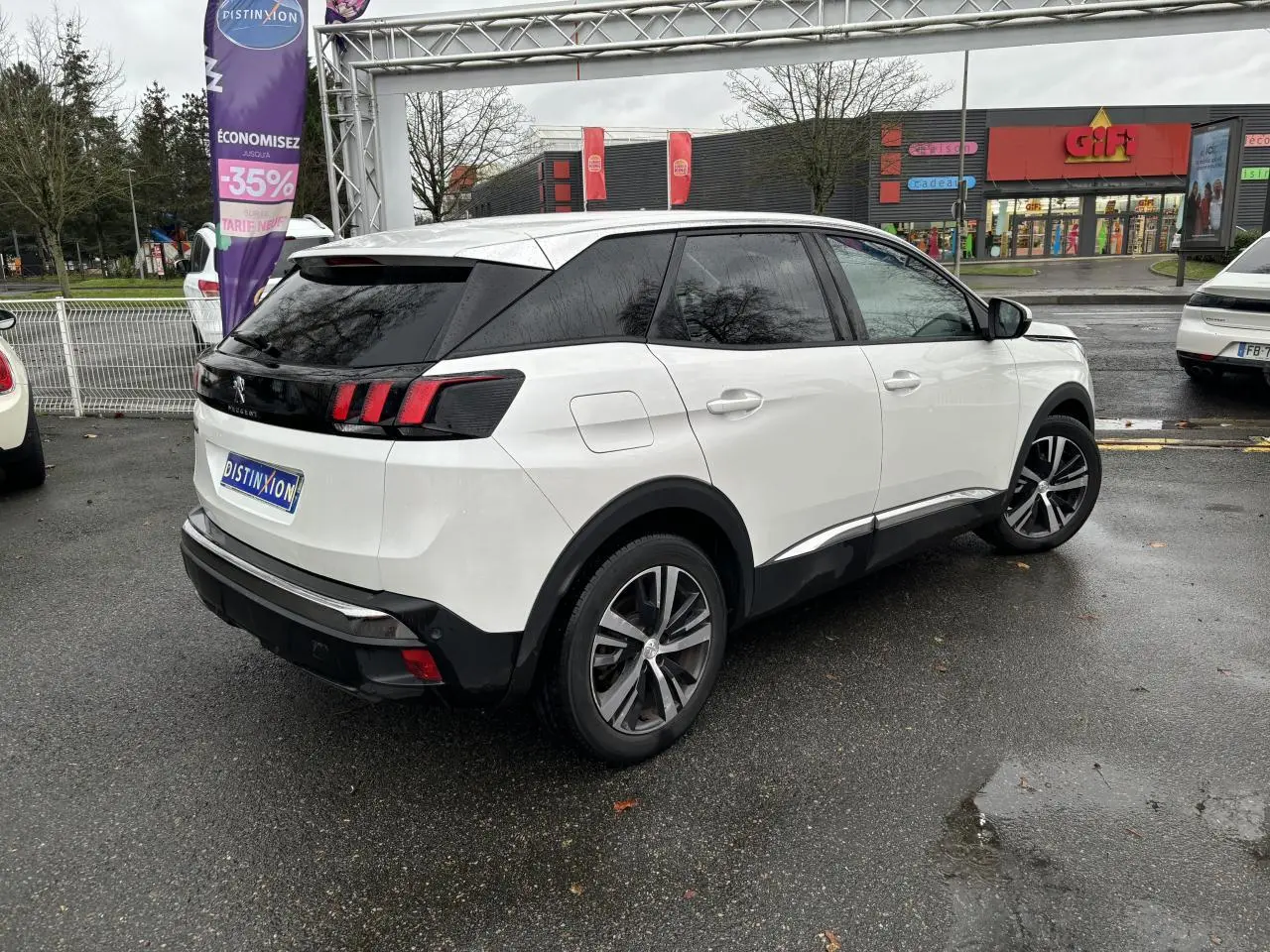 Vue 3/4 arrière droite d'un Peugeot 3008 blanc nacré avec vitres surteintées et jantes alliage 18 pouces.