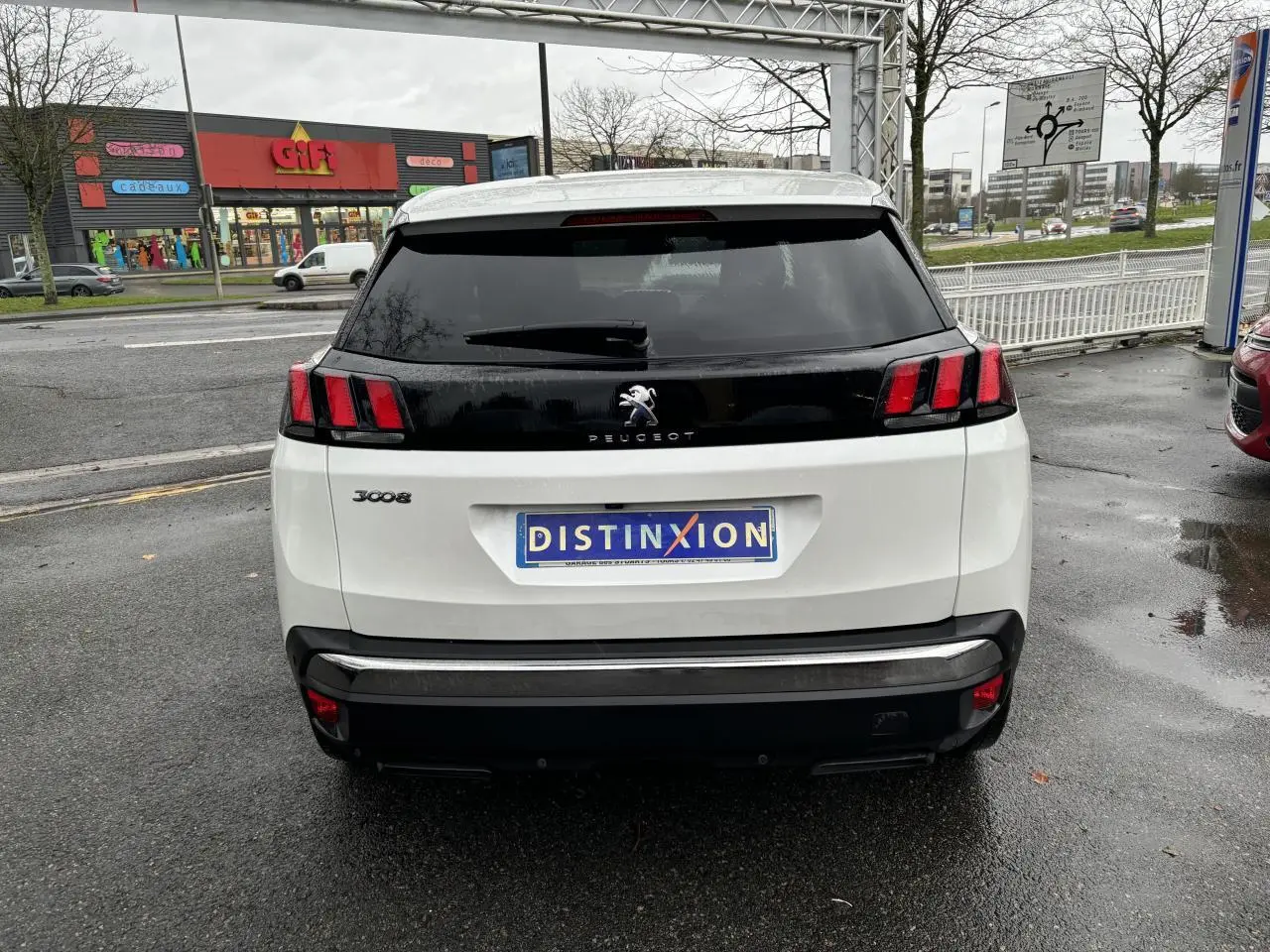 Vue arrière d'un Peugeot 3008 blanc nacré avec feux arrière à trois griffes et lunette arrière surteintée.