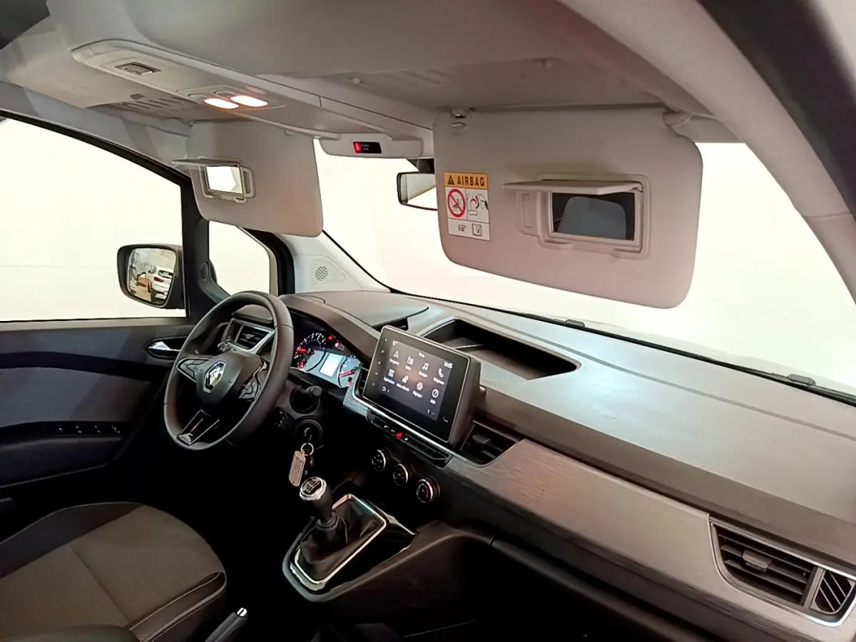 Intérieur avant droit du Renault Kangoo 2023 bleu, tableau de bord moderne avec écran tactile et volant multifonctions.