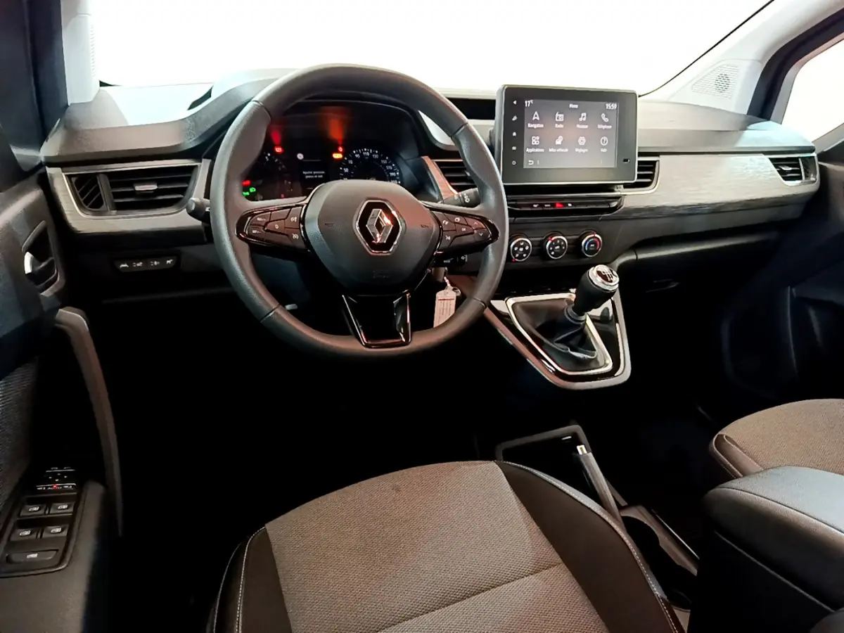 Vue intérieure avant du Renault Kangoo 2023 avec tableau de bord moderne, volant multifonctions et écran tactile central.