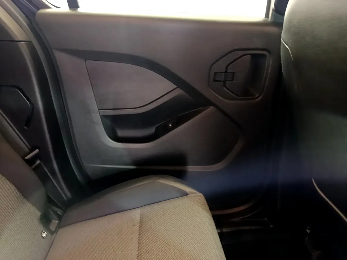 Vue intérieure côté droit arrière du Renault Kangoo 2023, montrant la portière noire et la banquette grise.