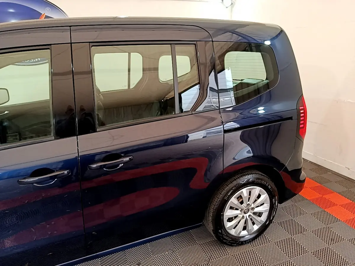 Profil arrière droit du Renault Kangoo bleu 2023 avec porte coulissante et feux arrière LED visibles.
