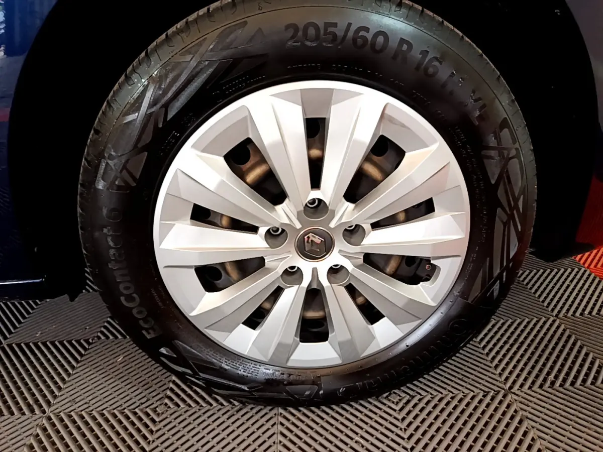 Gros plan sur la roue avant droite du Renault Kangoo bleu 2023 avec jante argentée et logo central Renault.