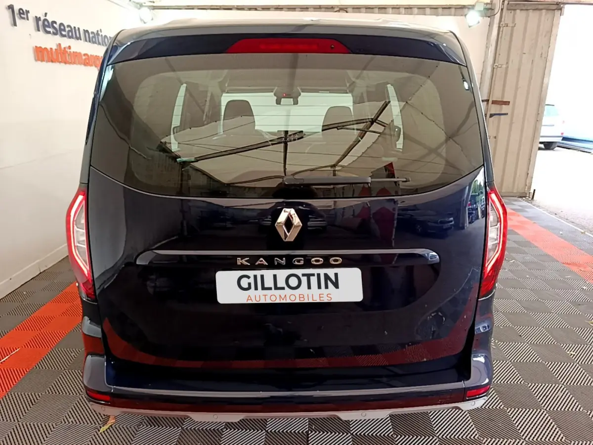 Vue arrière du Renault Kangoo bleu 2023 avec logo centré et feux arrière LED distinctifs visibles.