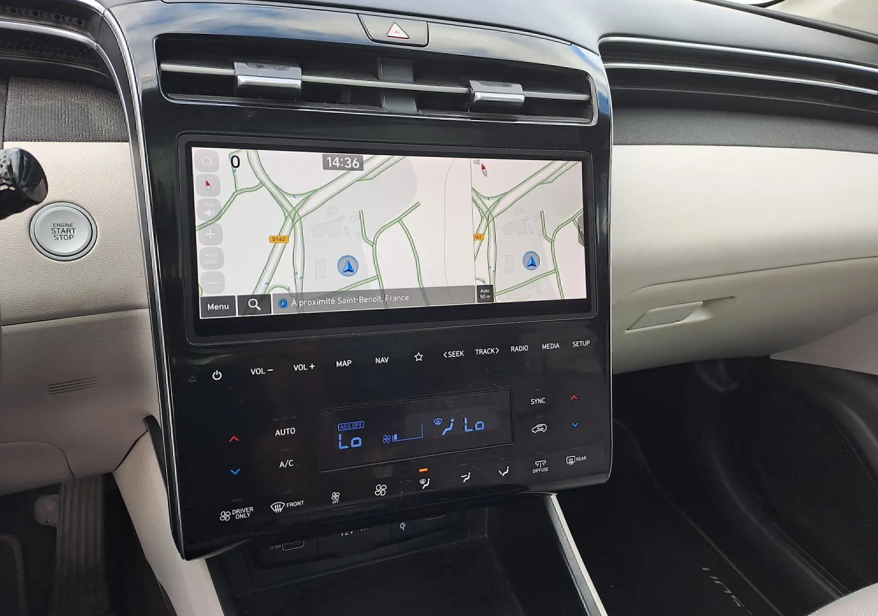 Vue rapprochée du tableau de bord beige du Hyundai Tucson 2023 avec écran tactile et commandes climatisation digitales.