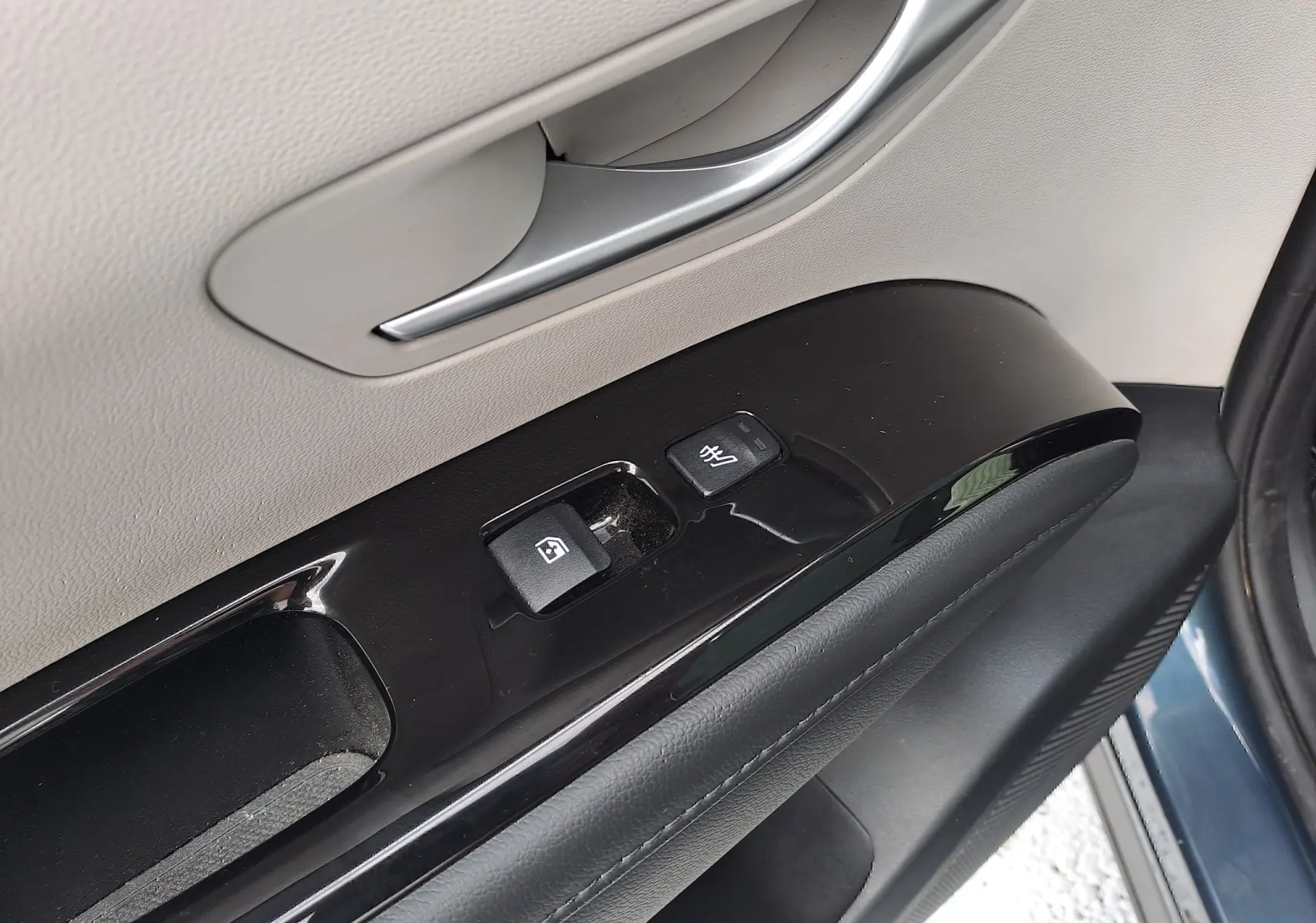 Gros plan sur la commande de lève-vitre et rétroviseur chauffant côté conducteur du Hyundai Tucson Cypress Green 2023.
