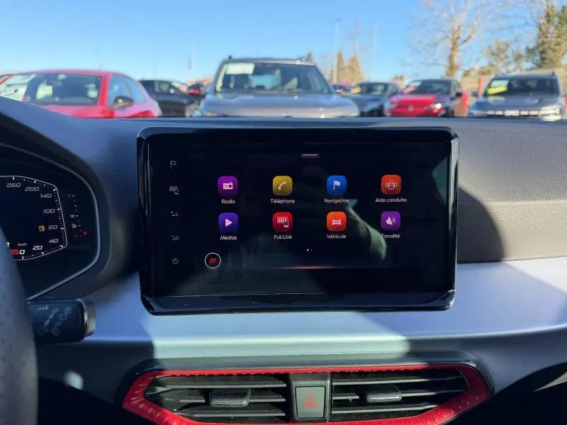 Vue intérieure centrée sur l'écran tactile du tableau de bord du SEAT Ibiza blanc Nevada métal, version 1.0 TSI FR.