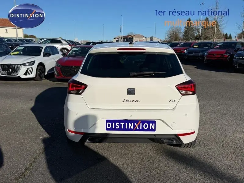 Vue arrière d'une SEAT Ibiza 1.0 TSI FR blanche Nevada métal, avec feux arrière anguleux et double sortie d'échappement.