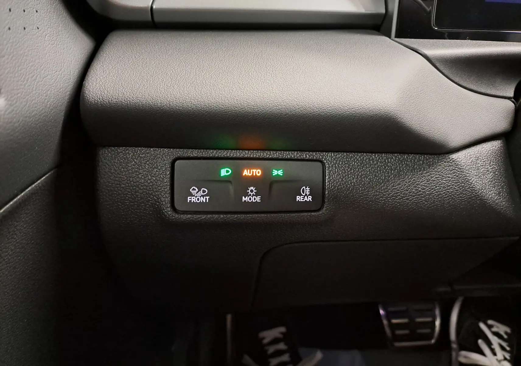 Gros plan sur le panneau de commande d’éclairage intérieur noir du Volkswagen T-Roc 2026, avec voyants verts et orange allumés.