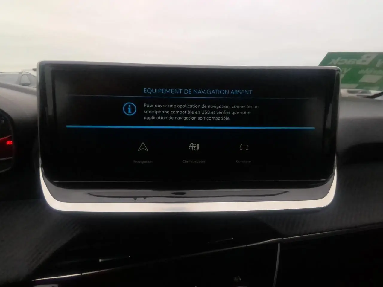 Écran tactile central du tableau de bord de la Peugeot 208 gris clair, affichant un message d'absence de navigation.
