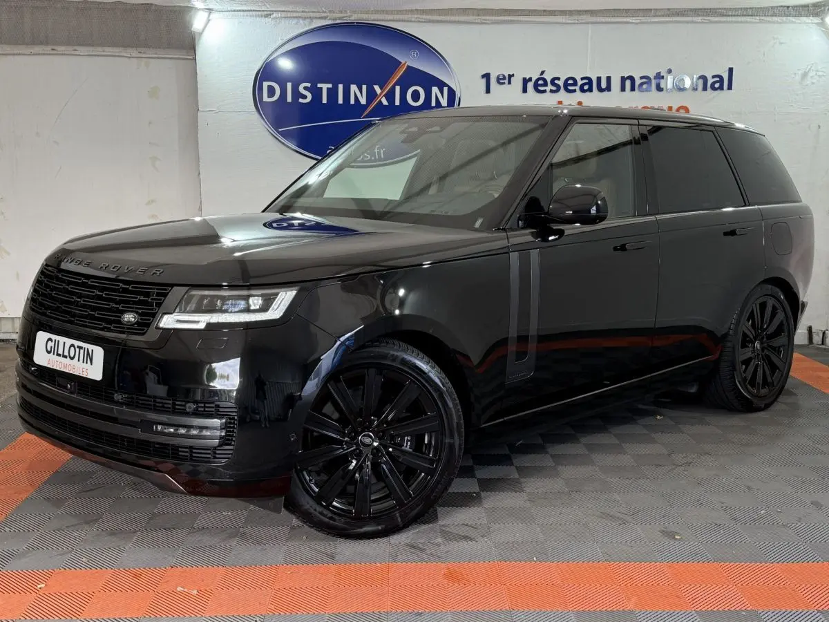 Range Rover PHEV P550e noir, vue 3/4 avant droit, jantes noires et vitres teintées dans un showroom.