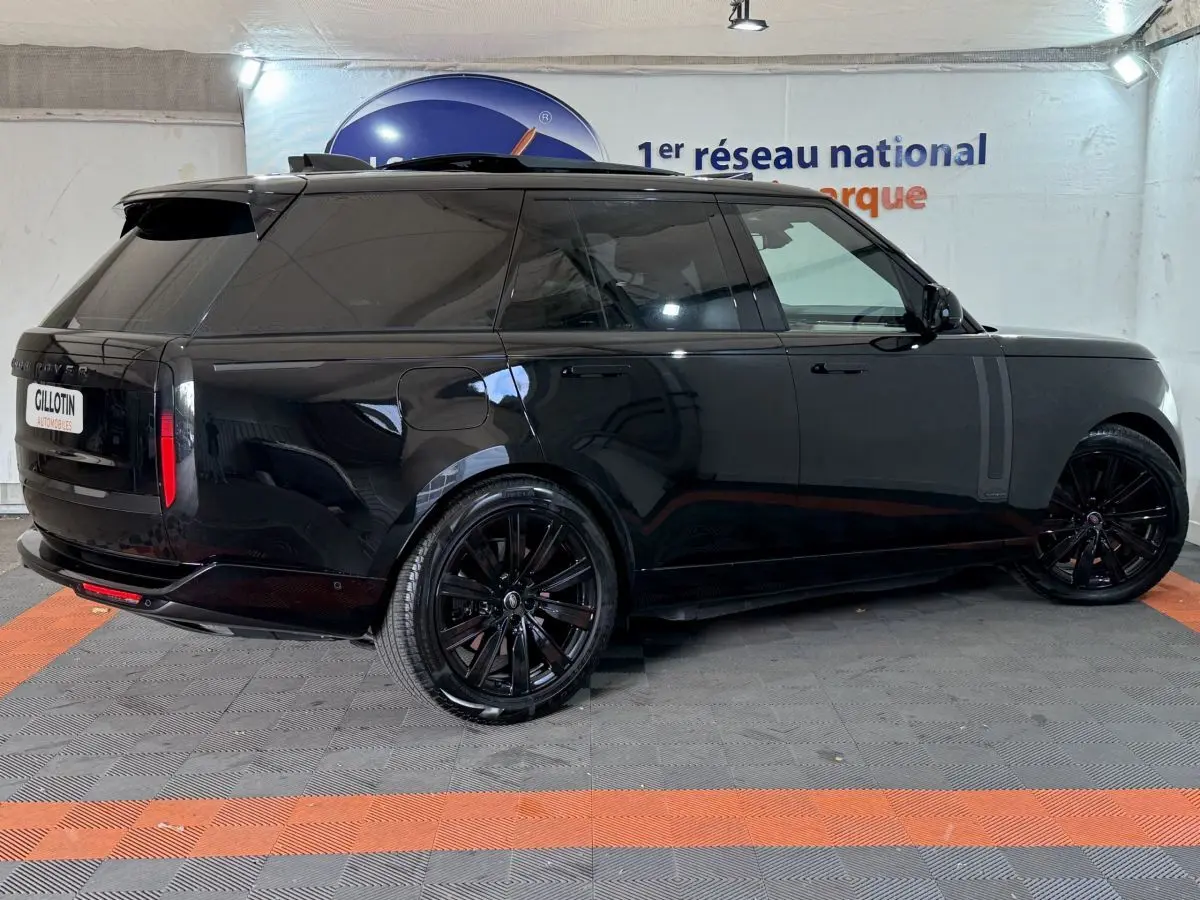 Vue 3/4 arrière côté droit d'un Range Rover PHEV P550e Autobiography noir brillant avec jantes noires et vitres teintées.