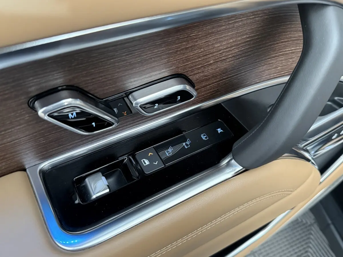 Détail des commandes de réglage de siège et fenêtre sur la portière côté conducteur du Range Rover noir 2024.