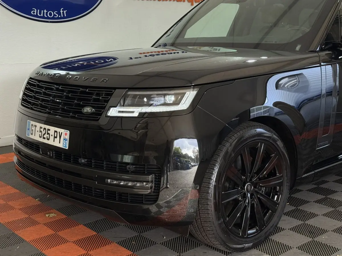 Vue 3/4 avant droite du Range Rover PHEV P550e Autobiography noir brillant avec jantes noires et calandre distinctive.