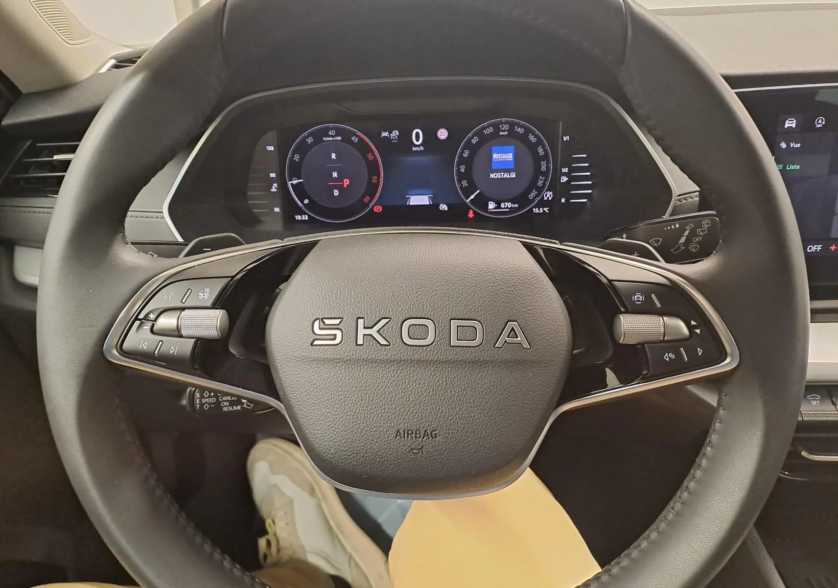 Vue centrée sur le volant cuir noir de la Skoda Octavia Combi 2025 avec tableau de bord digital et commandes intégrées.